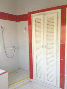 a bathroom with red and white walls and a shower at One bedroom appartement with sea view private pool and enclosed garden at Ouoran 1 km away from the beach in Ouoran