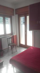 a bedroom with a bed and a chair and windows at One bedroom apartement with wifi at Calvello in Calvello