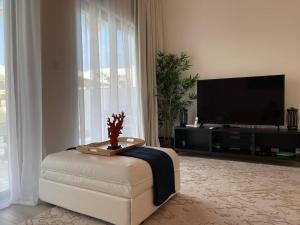 a living room with a television and a white chair at The White villa in Fujairah