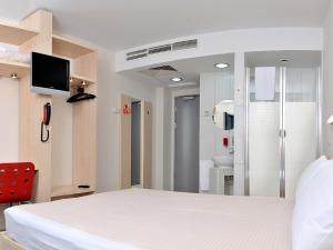 a bedroom with a white bed and a bathroom at Hello Hotels Gara de Nord in Bucharest