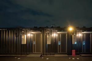 - une rangée de toilettes portatives la nuit avec éclairage dans l'établissement HOTEL R9 The Yard Utsunomiya chuo, à Utsunomiya