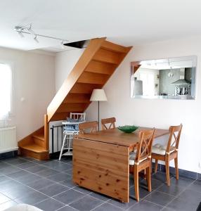 ein Wohnzimmer mit einem Holztisch und einer Treppe in der Unterkunft Maison de 2 chambres a Varaville a 400 m de la plage avec jardin clos et wifi in Varaville