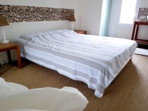 ein Schlafzimmer mit einem großen Bett mit einer weißen Bettdecke in der Unterkunft Maison de 2 chambres a Varaville a 400 m de la plage avec jardin clos et wifi in Varaville