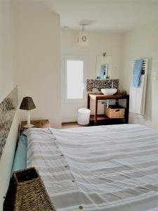 ein Schlafzimmer mit einem großen Bett und einem Waschbecken in der Unterkunft Maison de 2 chambres a Varaville a 400 m de la plage avec jardin clos et wifi in Varaville