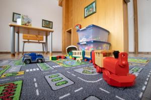 a childs room with a toy train on a rug at Hotel Bären in Gsteig