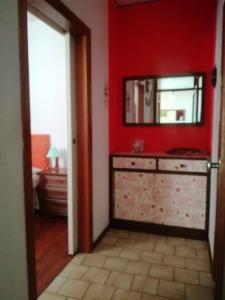 a red room with a dresser and a mirror at 3 bedrooms house at Marina di Ravenna 400 m away from the beach with enclosed garden and wifi in Marina di Ravenna