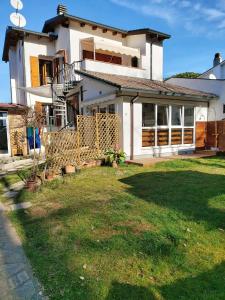 a house with a lawn in front of it at 3 bedrooms house at Marina di Ravenna 400 m away from the beach with enclosed garden and wifi in Marina di Ravenna
