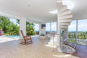 escalera en la sala de estar con vistas al océano en Villa de 2 chambres avec vue sur la mer piscine privee et jardin clos a Sainte Rose, en Sainte-Rose