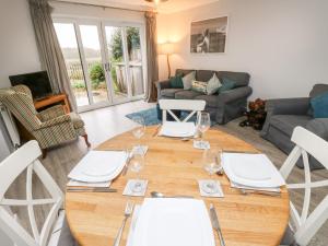 a living room with a wooden table with wine glasses at Windy Ridge Cottage in Yarmouth