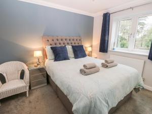 a bedroom with a bed with towels on it at Windy Ridge Cottage in Yarmouth