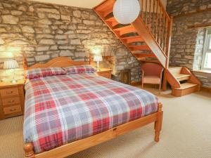 a bedroom with a bed and a stone wall at The Farmhouse in Ciliau-Aeron