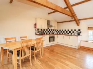 a kitchen and dining room with a wooden table and chairs at The Stable in Lampeter