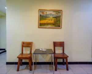 una mesa con dos sillas y una foto en la pared en RedDoorz Plus @ Hotel Asih UNY en Yogyakarta
