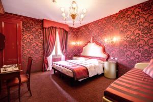 1 dormitorio con paredes rojas, 1 cama y 1 mesa en Domus Cavanis, en Venecia
