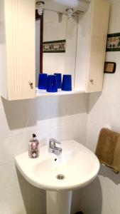 a white sink in a bathroom with blue glasses at 7 bedrooms house with furnished terrace and wifi at Gamiz Fica in Fica