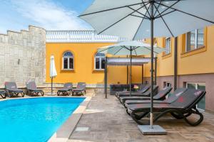 a group of chairs and an umbrella next to a pool at Villa Marko in Medulin