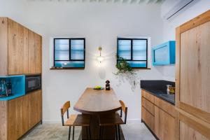 a kitchen with a wooden table and some windows at Daya - Old City Acre in Acre