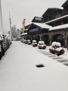 un parcheggio coperto di neve di fronte a un edificio di iH Hotels Courmayeur Mont Blanc a Courmayeur