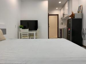 ein Schlafzimmer mit einem weißen Bett und einem Tisch in der Unterkunft Smiley Apartment Quận 2 in Ho-Chi-Minh-Stadt