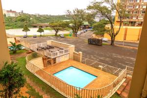 un balcón con vistas a la piscina y al aparcamiento en L'escalier Cabanas 107, en Amanzimtoti