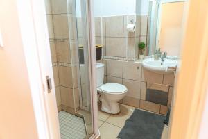 un baño con inodoro y lavabo en L'escalier Cabanas 107, en Amanzimtoti 21 fotos más