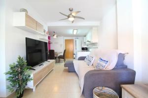 a living room with a couch and a flat screen tv at Global Properties, Apartamento en la playa de Canet d'en Berenguer in Canet de Berenguer