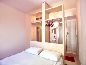 a bedroom with a mirror and a bed with white sheets at Hello Hotels Gara de Nord in Bucharest