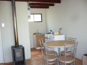 a kitchen with a table and chairs and a stove at El Parador de Caleu in Tiltil