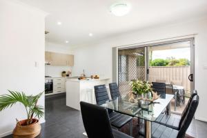 a kitchen and dining room with a glass table and chairs at The Willows in Mudgee