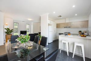a kitchen and living room with a glass table and chairs at The Willows in Mudgee