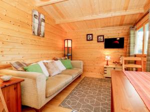 ein Wohnzimmer mit einem Sofa in einem Blockhaus in der Unterkunft Beckside Lodge in Malton