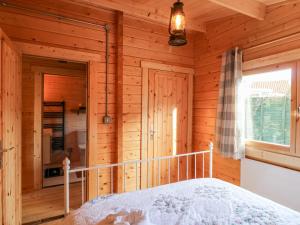 ein Schlafzimmer mit einem Bett in einer Holzhütte in der Unterkunft Beckside Lodge in Malton