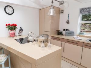 a kitchen with a counter and a clock on the wall at Elv Cottage in Chester +20 photos