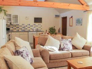 a living room with two couches and a kitchen at Cranberry Cottage in Shrewsbury