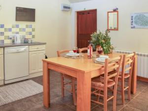 a kitchen with a wooden table and chairs at Cranberry Cottage in Shrewsbury +11 photos