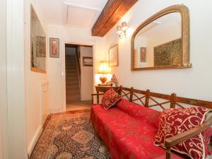 a living room with a red couch and a mirror at Colly Cottage in Bridport