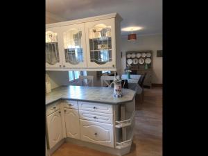 a kitchen with white cabinets and a counter top at Y Buarth in Llansaint