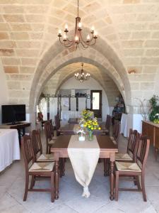 a dining room with a table and chairs and a chandelier at Masseria San Martino in Fasano