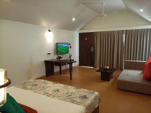 a living room with a flat screen tv at Resort Terra Paraiso in Calangute