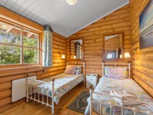 a bedroom with two beds in a log cabin at Bluebells in Beaworthy