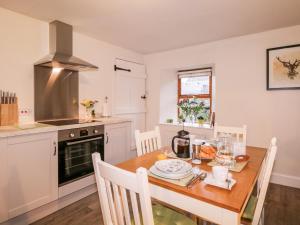 a kitchen with a wooden table and a stove top oven at Stonywood Cottage in Drumnadrochit