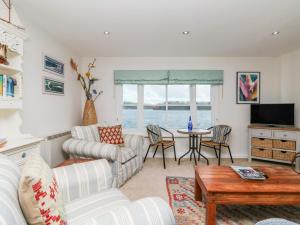 ein Wohnzimmer mit Sofa und Tisch in der Unterkunft Pier Cottage in Saint Mawes