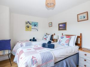 zwei Betten in einem Zimmer mit weißen Wänden in der Unterkunft Pier Cottage in Saint Mawes