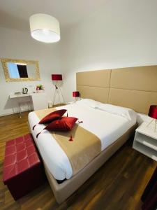 a bedroom with a large white bed with red pillows at Mapi’s Rooms in Cagliari