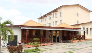 ein Gebäude mit einer Palme davor in der Unterkunft The Congress Hotel in Accra