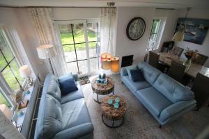 a living room with blue couches and a table at Strandperle 83 in Julianadorp
