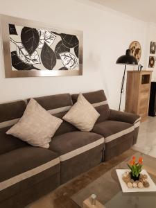 een woonkamer met een bruine bank en een tafel bij HR PARADISE CALA DE LA VILA JOIOSA in Cala de Finestrat