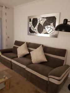 a brown couch in a living room with a lamp at HR PARADISE CALA DE LA VILA JOIOSA in Cala de Finestrat