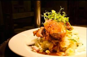 a plate of food with meat and cabbage on a table at Benedicts Hotel in Belfast