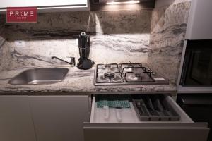 a kitchen counter with a stove and a sink at Prime Select El Batal in Cairo